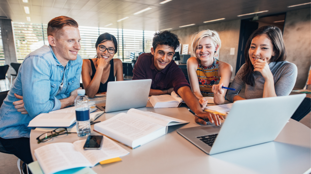 Adults at desk looking at laptop